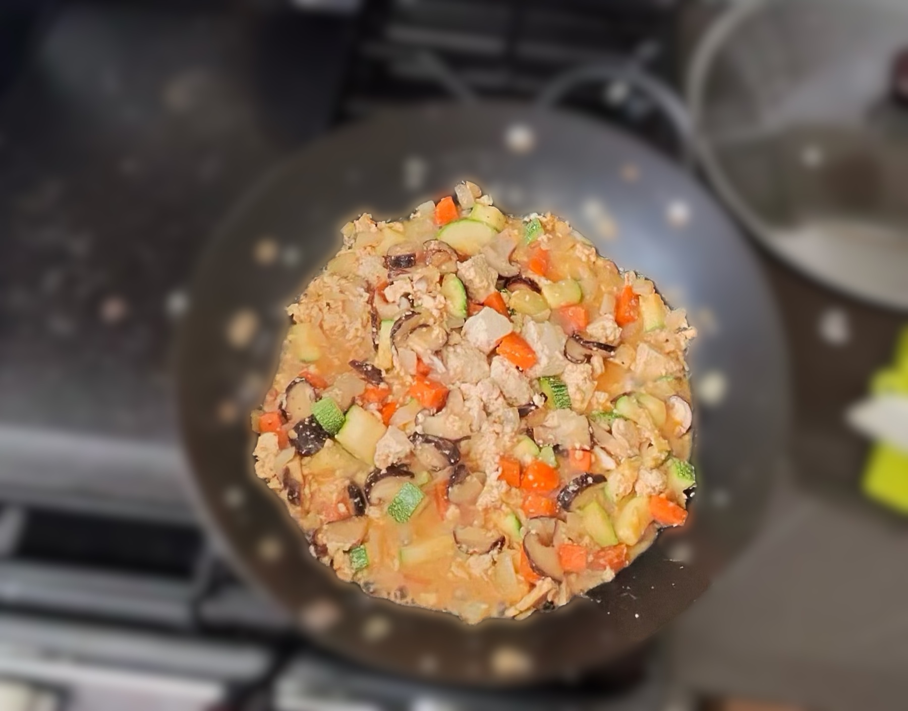 A wok of finished gangdoenjang — crumbled tofu with diced vegetables in a thick reddish-brown doenjang sauce