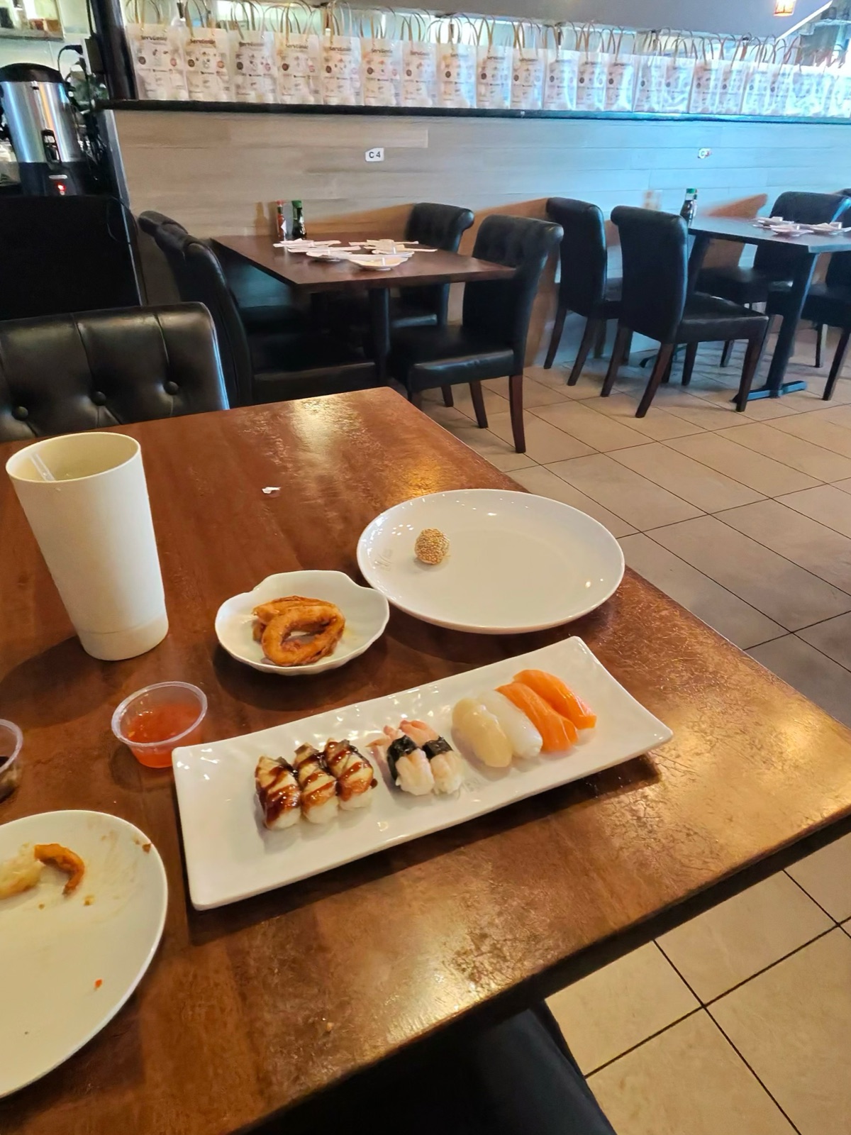 A plate of assorted nigiri at Sushi Oishii — eel, white fish, salmon and other cuts lined up on a rectangular white dish